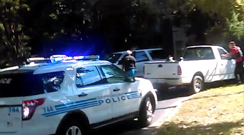 In this image taken from video recorded by Rakeyia Scott on Tuesday, Sept. 20, 2016, her husband, Keith Lamont Scott, center, stands amid Charlotte police cars and other vehicles moments before he is shot by a police officer in Charlotte, N.C. In the video of the deadly encounter, Rakeyia Scott repeatedly tells officers her husband, who is black, is not armed and pleads with them not to shoot him as they shout at him to drop a gun. The video does not show clearly whether Scott had a gun. (Rakeyia Scott/Curry Law Firm via AP)