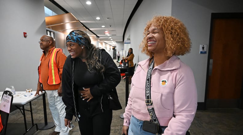First-time voter Georrea Baker, 18, of Marietta is congratulated by her mother. Georgina Baker, after casting her ballot Tuesday during early voting at the Cobb County Elections and Registration Main Office in Marietta. (Hyosub Shin / AJC)
