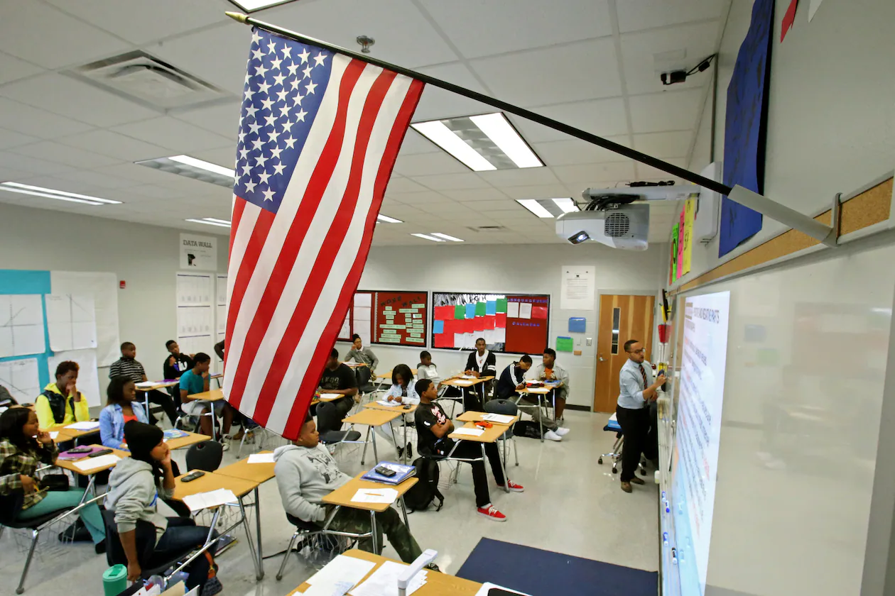 Below a U.S. flag, mathematics teacher Evan Shields teaches a ninth grade algebra class at Banneker High School in College Park. (Jason Getz/AJC 2013)