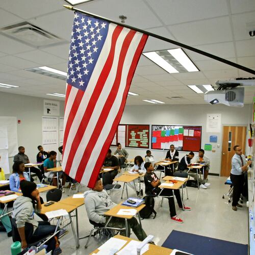Below a U.S. flag, mathematics teacher Evan Shields teaches a ninth grade algebra class at Banneker High School in College Park. (Jason Getz/AJC 2013)