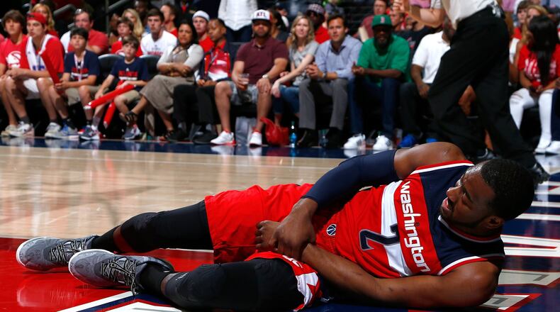 John Wall of the Wizards grabs his wrist after missing a basket and landing on the floor against the Hawks during Game 1 of their Eastern Conference semifinals series at Philips Arena on May 3. (Photo by Kevin C. Cox/Getty Images)