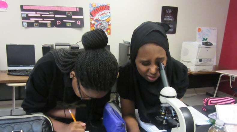 Sherifat Akinniyi (left) and Natoli Bora work in the science lab of the DeKalb Early College Academy in Stone Mountain. The school’s compressed course load allows students to enroll in college courses for their last two years of high school.