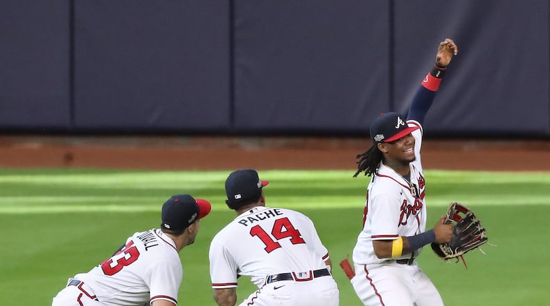 100720 Houston: Atlanta Braves Adam Duvall (from left), Cristian Pache, and Ronald Acuna act like they are taking a selfie while celebrating a 2-0 victory over the Miami Marlins during Game 2 of a National League Division Series at Minute Maid Park on Wednesday, Oct 7, 2020 in Houston.   “Curtis Compton / Curtis.Compton@ajc.com”