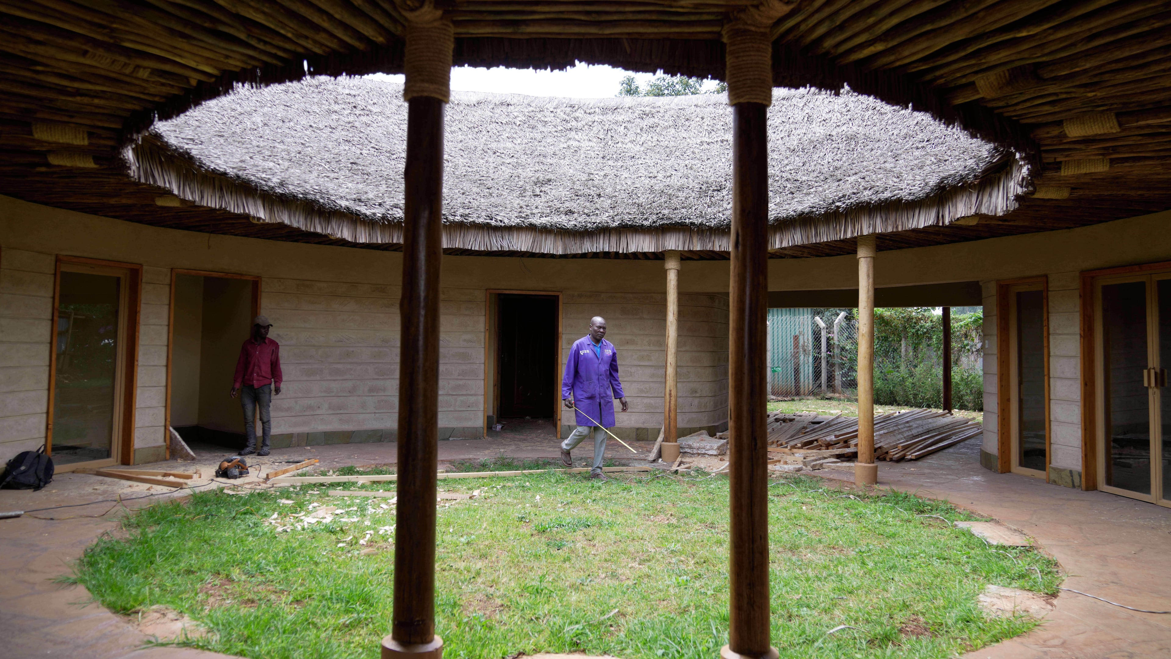 A contractor takes measurements inside a house under construction, inspecting wall and roof insulation made from agricultural waste and mushroom mycelium in Nairobi, Kenya, Friday, Sept. 12, 2025. (AP Photo/Brian Inganga)