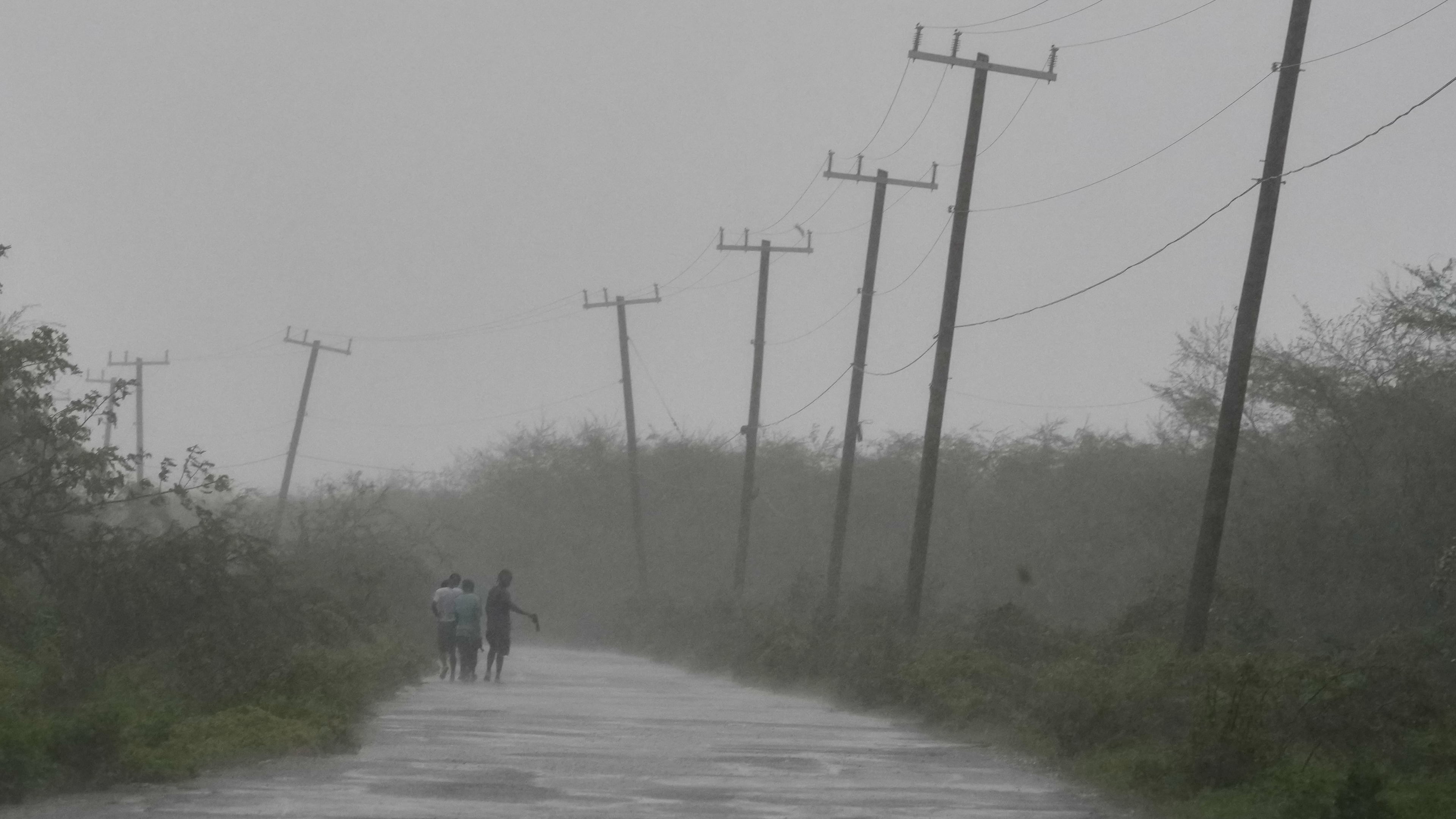 People walk along a road during the passing of Hurricane Melissa in Rocky Point, Jamaica, Tuesday, Oct. 28, 2025. (AP Photo/Matias Delacroix)