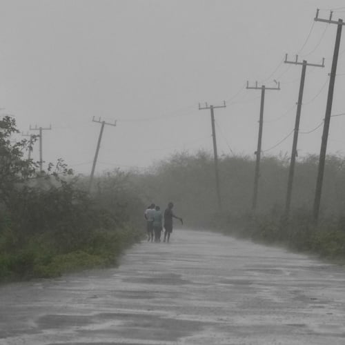 People walk along a road during the passing of Hurricane Melissa in Rocky Point, Jamaica, Tuesday, Oct. 28, 2025. (AP Photo/Matias Delacroix)