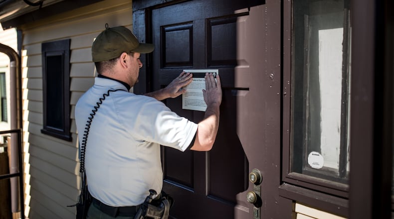 A National Park Service ranger posts sign about the government shutdown at Martin Luther King Jr.'s childhood home, which was closed Saturday, Jan. 20, 2018. BRANDEN CAMP/SPECIAL