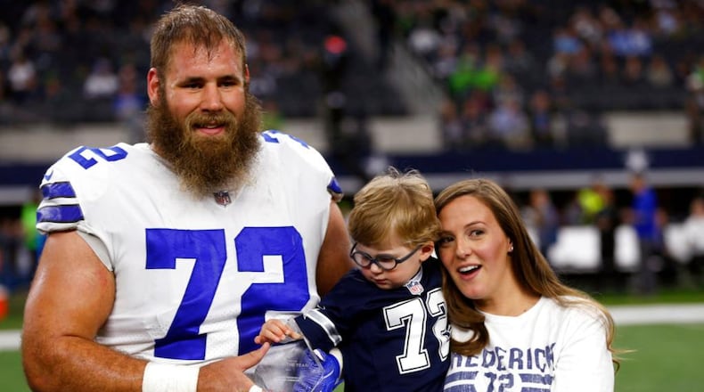 FILE - In this Dec. 24, 2017, file photo, Dallas Cowboys center Travis Frederick (72), and his wife Kaylee, right, pose for a photo as their son Oliver, reaches out to the NFL Man of the Year team nominee award presented to Frederick before an NFL football game against the Seattle Seahawks, in Arlington, Texas. Frederick's revelation that he is battling a rare neurological disorder will reverberate on and off the field for the Dallas Cowboys. They're likely to begin the season without their stalwart at center, and without knowing what will happen with their teammate's recovery. (AP Photo/Ron Jenkins, File)