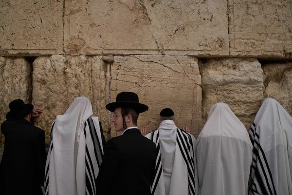 Covered in prayer shawls, Jewish men of the Cohanim Priestly caste participate in a blessing during the holiday of Passover, at the Western Wall, the holiest site where Jews can pray, in the Old City of Jerusalem, Tuesday, April 15, 2025. (AP Photo/Leo Correa)