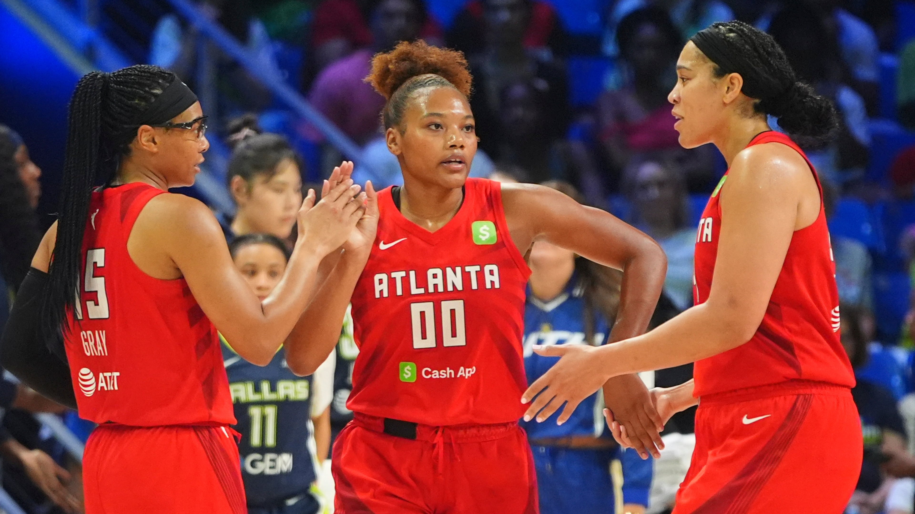 Atlanta Dream forward Naz Hillmon (00) celebrates with teammates guard Allisha Gray (left) and forward Brionna Jones (right) during the second half of a WNBA basketball game against the Dallas Wings in Arlington, Texas, Wednesday, July 30, 2025. (LM Otero/AP)