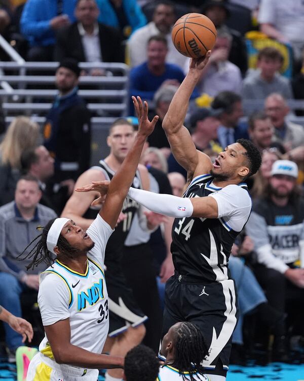 Milwaukee Bucks forward Giannis Antetokounmpo (34) shoots over Indiana Pacers center Myles Turner (33) during the first half of a first-round NBA basketball playoff game in Indianapolis, Tuesday, April 22, 2025. (AP Photo/Michael Conroy)