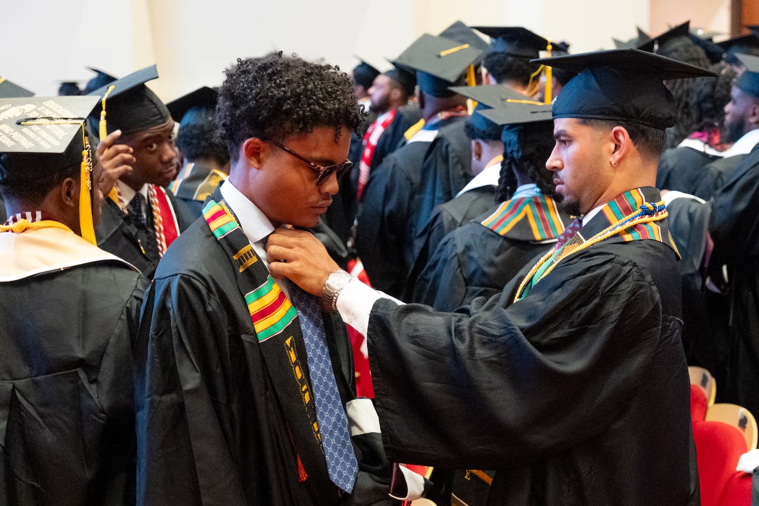 Earle Horton (left) gets a little help with his tie from Brogan Korta as they prepare for the Morehouse College graduation Sunday, May 17, 2026. (Ben Gray for the AJC)
