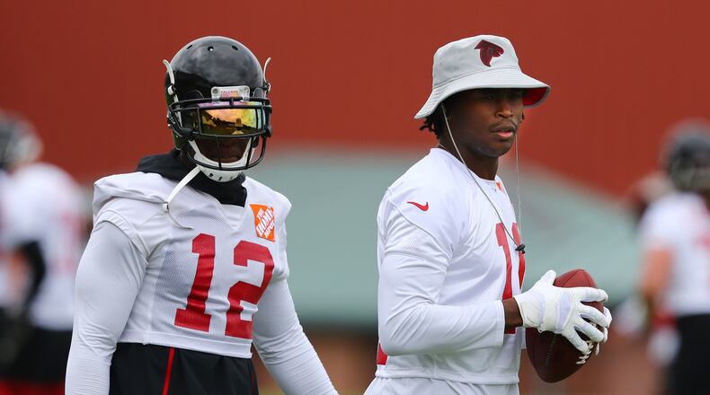 Receivers Mohamed Sanu and Julio Jones watch younger players run routes during Wednesday's action. (Curtis Compton/ccompton@ajc.com)