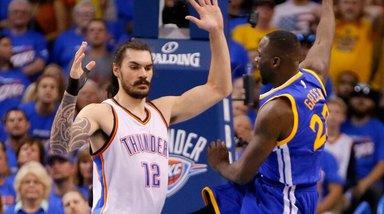 Golden State's Draymond Green's delivers a shot between the legs of Oklahoma City's Steven Adams during Game 3 of the NBA's Western Conference finals Sunday night. (AP photo)