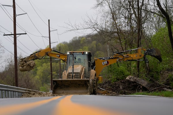 Workers clear landslide debris, caused by heavy rains overnight, from Mary Ingles Highway, Friday, April 4, 2025, in Newport, Ky. (AP Photo/Carolyn Kaster)
