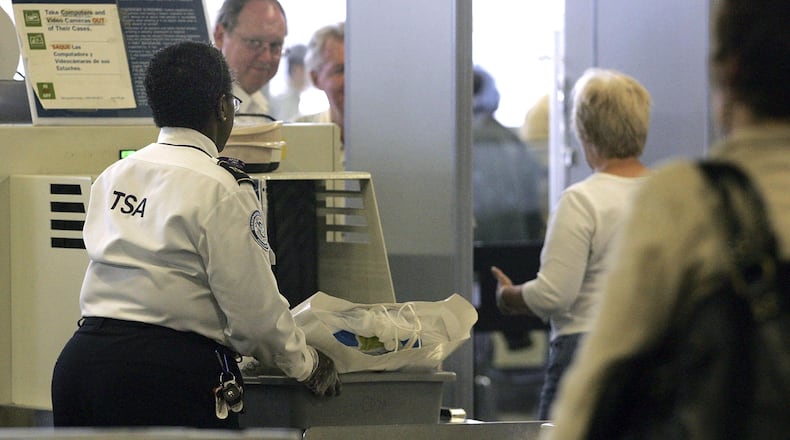 A TSA worker sends a traveler's belongings through an x-ray machine at a security checkpoint. As the partial government shutdown moves into its 25th day, more TSA workers are calling out because they're not getting paid.