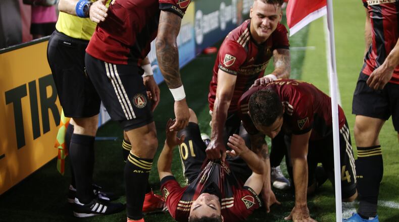 Atlanta United teammates pile on top of Miguel Almiron after he scored in the first half of Saturday’s game against Houston at Georgia Tech’s Bobby Dodd Stadium. (Miguel Martinez / Mundo Hispanico)