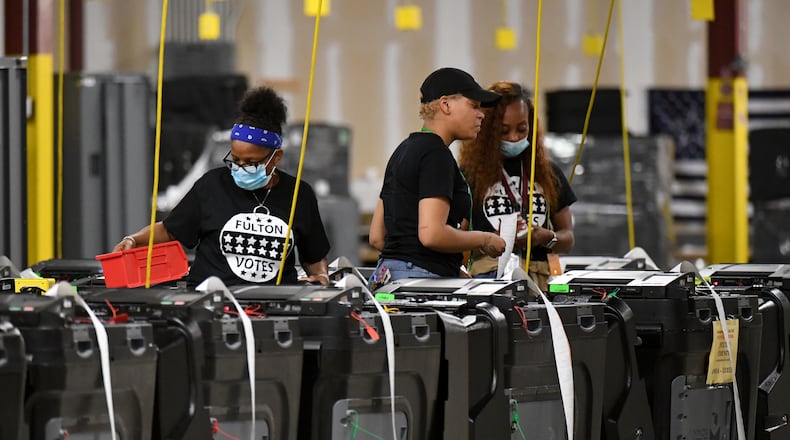 Fulton County election workers prepare before all voting machines come back to the warehouse at the Fulton County Election Preparation Center on May 24, the night of the Georgia primary. (Hyosub Shin / Hyosub.Shin@ajc.com)