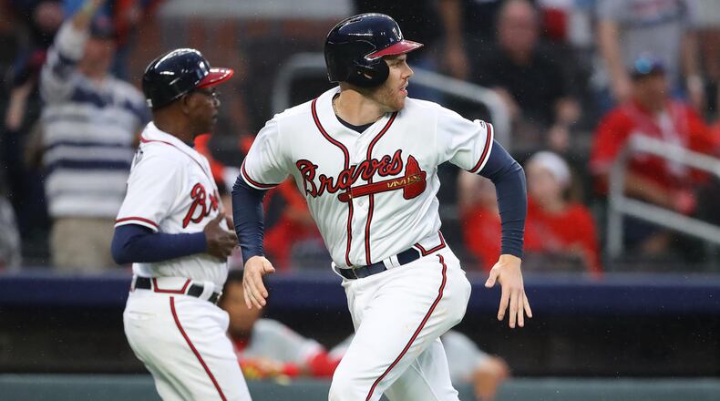 March 29, 2018 Atlanta: Atlanta Braves Freddie Freeman scores from second base on a wild pitch that advanced him to third and a errant throw to third sending him home during the eight inning against the Phillies in a MLB baseball home opening game on Thursday, March 29, 2018, in Atlanta.  Curtis Compton/ccompton@ajc.com