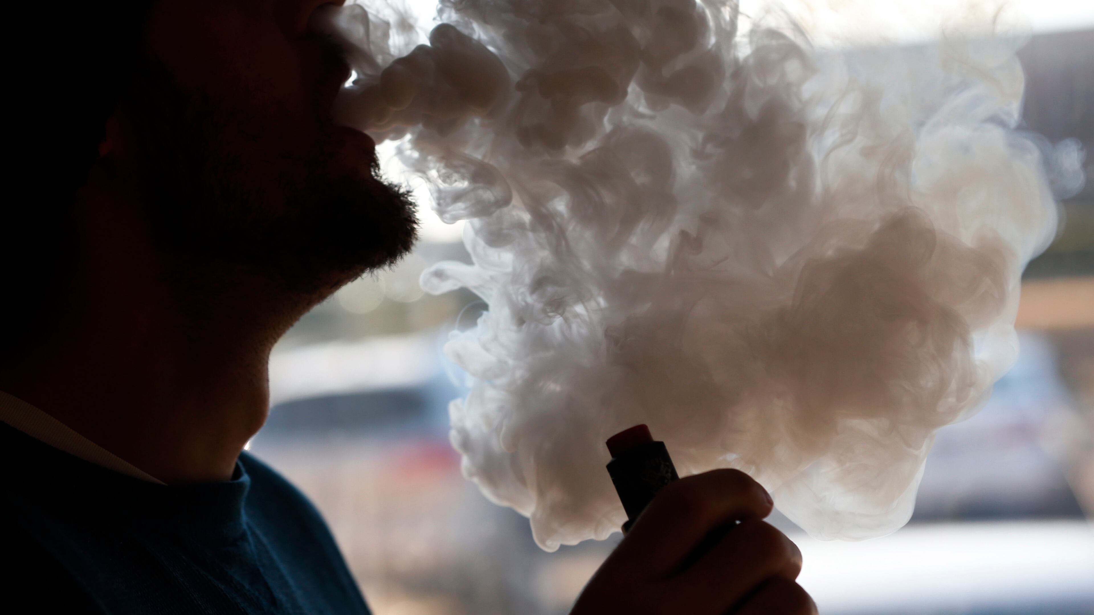 A customer blows a cloud of smoke from a vape pipe at a shop in Richmond, Va. The prevalence of consumable vapor products and device use among school-age children across Georgia has spurred both Atlanta’s elected officials and state legislators to explore ways to limit accessibility. (Steve Helber/AP 2019)