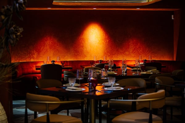 A dimly lit restaurant dining room with red walls