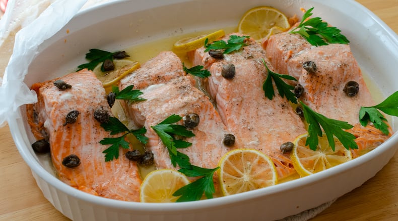 Steamed salmon filets with lemon, butter and capers combine for a classic combination in minutes with the help of a microwave.  / Virginia Willis for the AJC