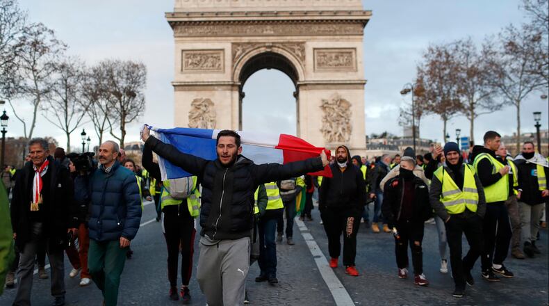 Demonstrators wearing yellow vests march down the Champs Elysees in Paris on Saturday.