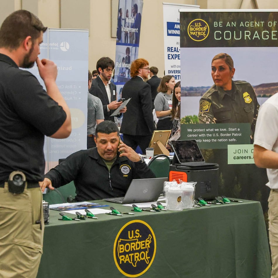 Representatives from U.S. Customs and Border Protection (CPB) work at a table during a career fair held by the University of Georgia’s at the Classic Center in Athens on Wednesday, Feb. 4, 2026. (Felix Scheyer for the AJC)