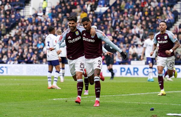 Aston Villa's Marcus Rashford, center right, celebrates scoring their side's first goal of the game with teammate Marco Asensio during the English FA Cup quarter final soccer match at Deepdale, Preston, England, Sunday, March 30, 2025. (Martin Rickett/PA via AP)