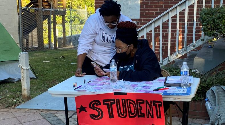 Spelman College students Rimothy Miracle Bennett, 19, a junior, and Jahni Lane-Foster, 18, a freshman, help at a table to collect complaints about student housing conditions and other issues at Atlanta's historically Black colleges. The complaints included mold and mildew in rooms and washers and dryers that don't work. (Eric Stirgus/eric.stirgus@ajc.com)