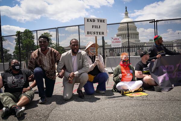 Protesters block a street between the Capitol and the Supreme Court building in Washington, demonstrating for the passage of the For the People Act, and an end to the filibuster. The Justice Department sued Georgia over a sweeping voting law passed by the state’s Republican-led legislature, Attorney General Merrick Garland announced. (Sarahbeth Maney/The New York Times)