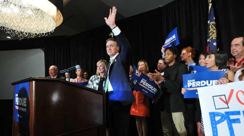 May 20, 2014 Atlanta - David Perdue waves to his supporters as his wife Bonnie stands next to him at his election night party at Doubletree Hotel in Buckhead on Tuesday, May 20, 2014. HYOSUB SHIN / HSHIN@AJC.COM David Perdue greets supporters in Buckhead (AJC/Hyosub Shin)