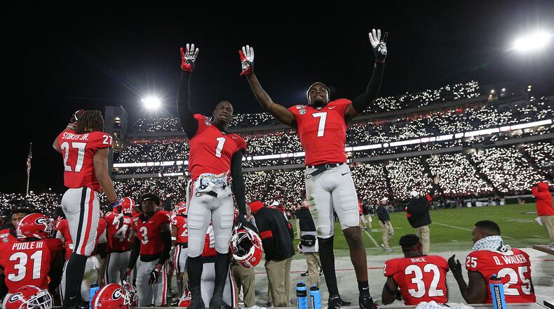 Georgia defensive backs Divaad Wilson (left) and Tyrique Stevenson signal the fourth quarter as fans light up Sanford Stadium during a 27-0 shutout over Missouri on Saturday, November 9, 2019, in Athens.