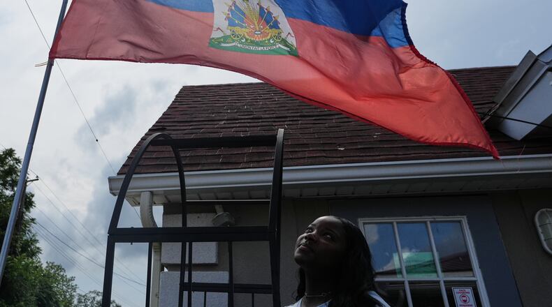 Patricia Grace Louis-Jacques, a nursing student who has close Haitian family members and friends affected by the end of TPS, poses for a photo outside the Caribbean Creole Café in Salisbury, Md., Sunday, Aug. 2, 2026. (AP Photo/Luis Andres Henao)