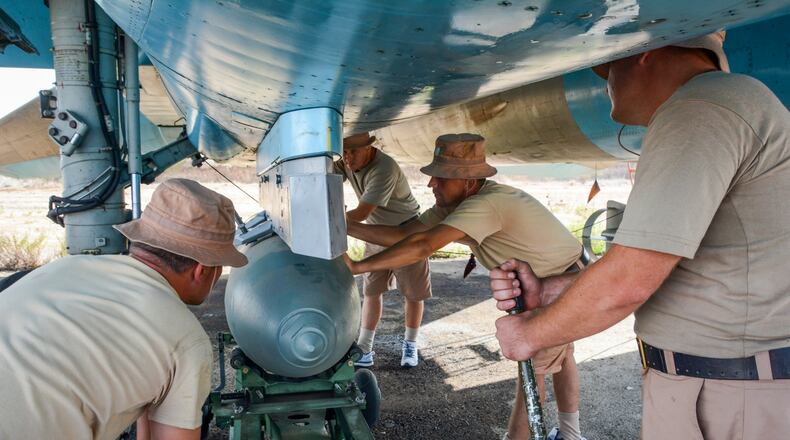 Ground crew members check an air-to-air missile under the wing of a Russian Su-30 fighter at Hemeimeem airbase, Syria, on Thursday. Russian jets regularly hit targets at night, a capability the Russian air force lacked until recently. AP/Vladimir Kondrashov