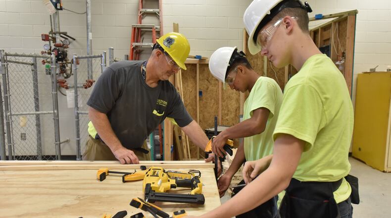 Kent Doehrman (left), Construction/HVACR teacher, helps students Marvin Rodas, 17, and Michael Lyons (right), 16, as they build book exchanges at Maxwell on Tuesday, October 15, 2019. Students from Maxwell High School of Technology, are partnering with Gwinnett Coalition for GREAT (Gwinnett Reading Exchange & Art Transforms) Little Minds initiative to provide access to books, encourage art appreciation. Those tiny libraries will now be on exhibit at The Hudgens Center before being placed in needed areas of the county. (Hyosub Shin / Hyosub.Shin@ajc.com)