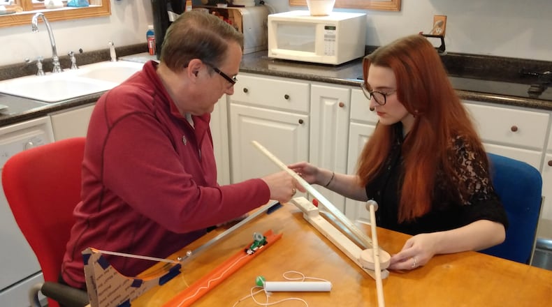 Oglethorpe University instructor Daniel Howard and his daughter, Jacqueline, try out his physics kit at their kitchen table.