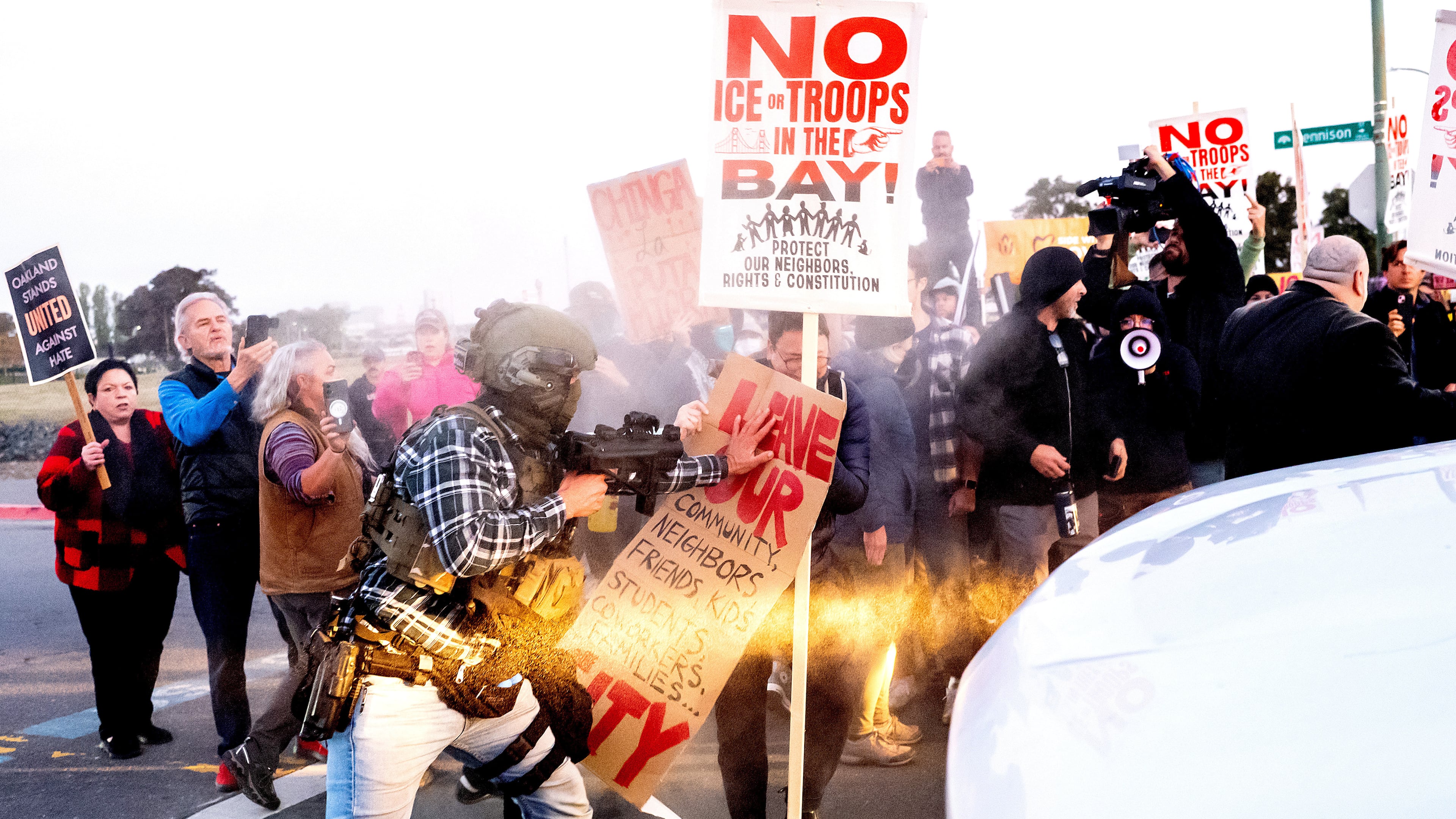 A person pushes a protester blocking a caravan of U.S. Customs and Border Protection personnel trying to enter Coast Guard Base Alameda on Thursday, Oct. 23, 2025, in Oakland, Calif. (AP Photo/Noah Berger)