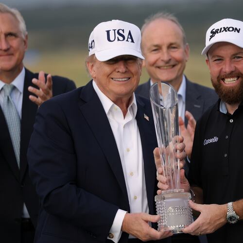 U.S. President Donald Trump presents the trophy to Irish Open golf winner Shane Lowry of Ireland whilst Ireland's Prime Minister Micheal Martin, center rear, looks on, at the Trump International Golf Links course in Doonbeg, Ireland, Sunday, Sept. 13, 2026. (AP Photo/Peter Morrison)