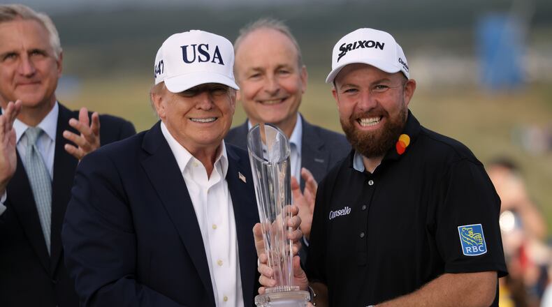 U.S. President Donald Trump presents the trophy to Irish Open golf winner Shane Lowry of Ireland whilst Ireland's Prime Minister Micheal Martin, center rear, looks on, at the Trump International Golf Links course in Doonbeg, Ireland, Sunday, Sept. 13, 2026. (AP Photo/Peter Morrison)