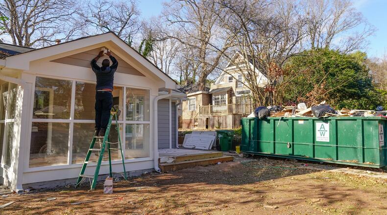 Sherrod Jefferson installs a motion-activated floodlight in December on an Atlanta home he bought to remodel and resell. (Elijah Nouvelage/Special to the Atlanta Journal-Constitution)