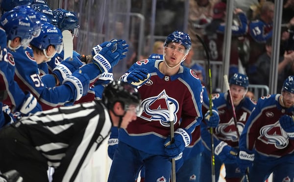 Colorado Avalanche center Martin Necas, center, is congratulated as he passes the team box after scoring in the second period of Game 6 of an NHL hockey first-round playoff series against the Colorado Avalanche, Thursday, May 1, 2025, in Denver. (AP Photo/David Zalubowski)