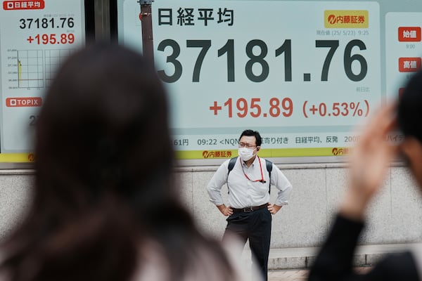 A person stands in front of an electronic stock board showing Japan's Nikkei index at a securities firm Friday, May 23, 2025, in Tokyo. (AP Photo/Eugene Hoshiko)