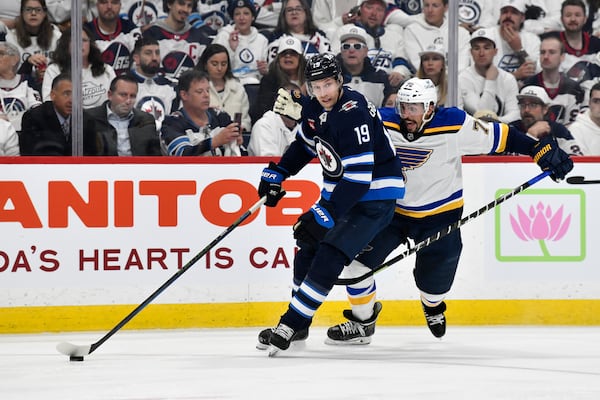 Winnipeg Jets' David Gustafsson (19) carries the puck past St. Louis Blues' Justin Faulk (72) during the second period of Game 2 of a first-round NHL hockey playoff series in Winnipeg, Manitoba, Monday April 21, 2025. (Fred Greenslade/The Canadian Press via AP)