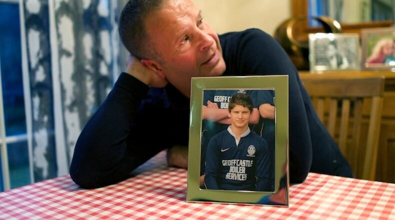 Peter Robinson with a photo of his son Benjamin who died at 14 years of age from multiple hits to the head during a rugby match, at home in Roslin, Scotland, Oct. 28, 2015. The efforts of Robinson and British scientist Willie Stewart have led to Scotland adopting a concussion protocol that applies not just to rugby but to all sports at all levels, from scholastic games to adult leagues, and is now seen as a model for other countries. (Kieran Dodds/The New York Times)