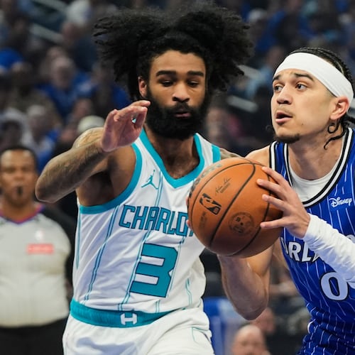 Orlando Magic guard Anthony Black (0) drives around Charlotte Hornets guard Coby White (3) during the first half of an NBA play-in tournament basketball game, Friday, April 17, 2026, in Orlando, Fla. (AP Photo/John Raoux)