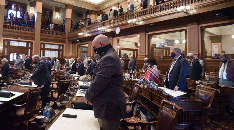 January 12, 2021 Atlanta - Georgia House representatives stand up and pray for Rep. Patty Bentley (not pictured, D-Butler) and her husband inside the House Chambers during the second day of the 2021 legislative session at the Georgia State Capitol building on Tuesday, January 12, 2021. (Hyosub Shin / Hyosub.Shin@ajc.com)