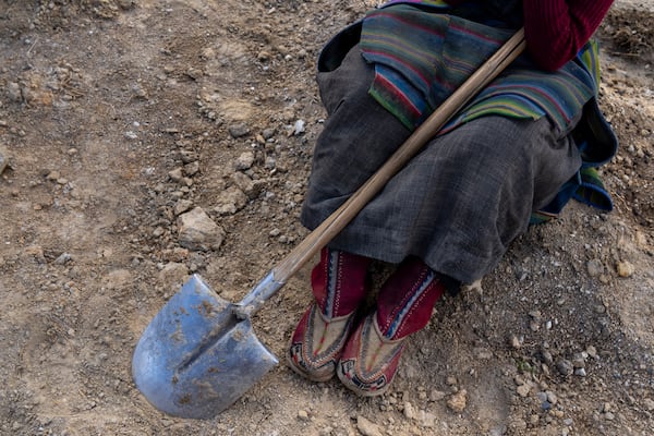 A woman takes a break from her work at the newly relocated settlement of the abandoned Samjung village in the Mustang region, 462 kilometers (288 miles) west of Kathmandu, Nepal, Friday, April 18, 2025. (AP Photo/Niranjan Shrestha)