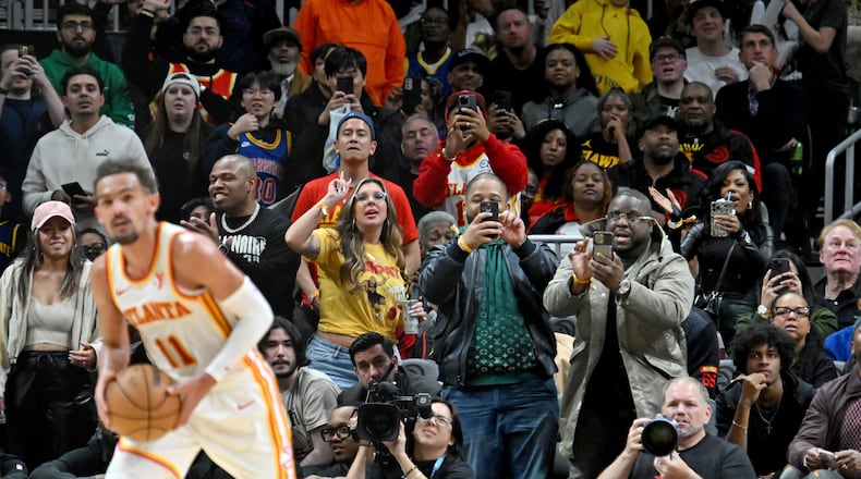 Basketball fans react as Atlanta Hawks guard Trae Young (11) brings the ball upcourt at the end of the fourth quarter in an NBA basketball game at State Farm Arena, Saturday, February 3, 2024, in Atlanta. Atlanta Hawks won 141-134 in overtime. (Hyosub Shin / Hyosub.Shin@ajc.com)