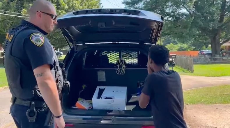 Officer Eric Colleran presents Keonte Evans with a PlayStation. Courtesy of Hapeville Police Department
